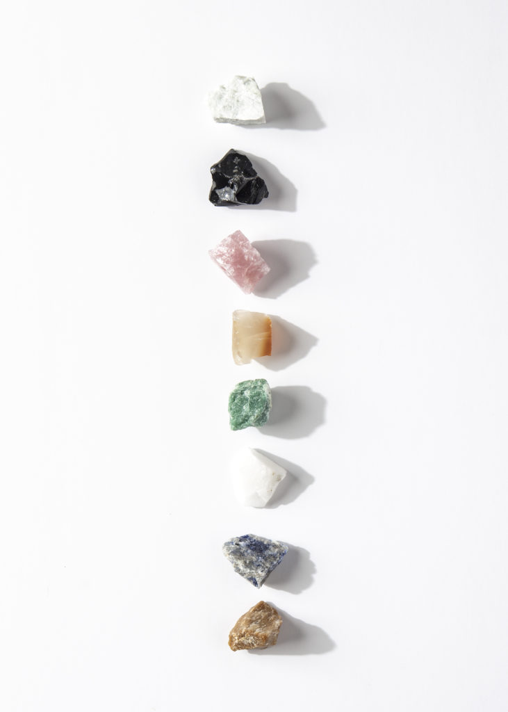 different colored mood stones in a line on a white background